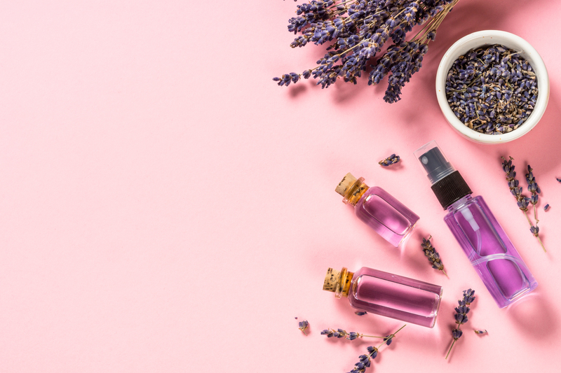 Lavender essential oil and perfume on pink.